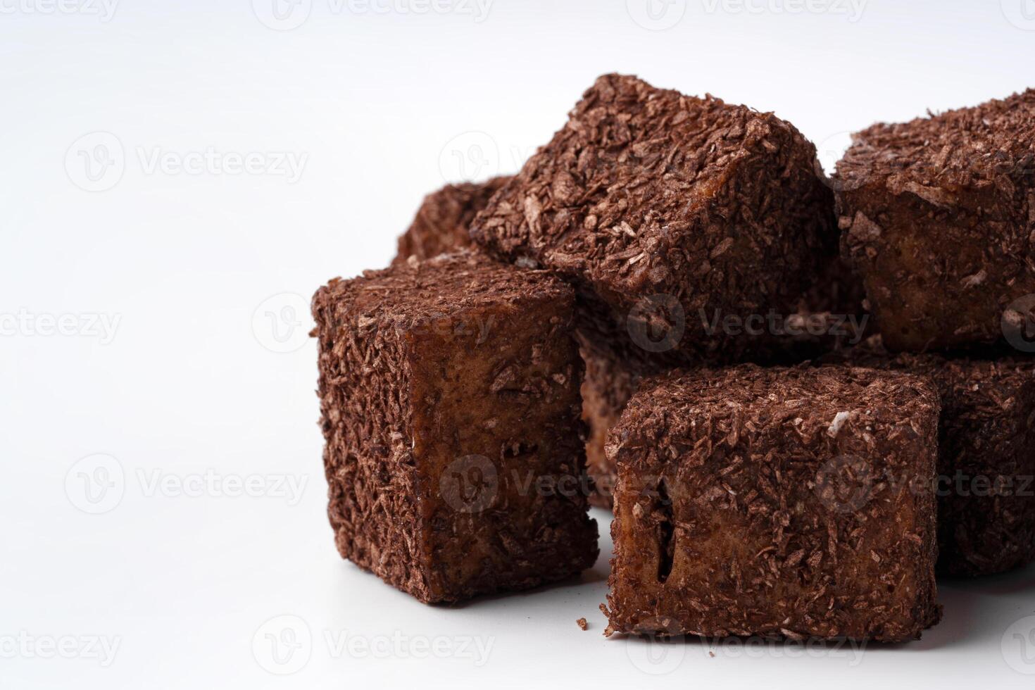 Delicious dark chocolate cubes stacked on a white background ready to be enjoyed as a sweet treat or dessert photo