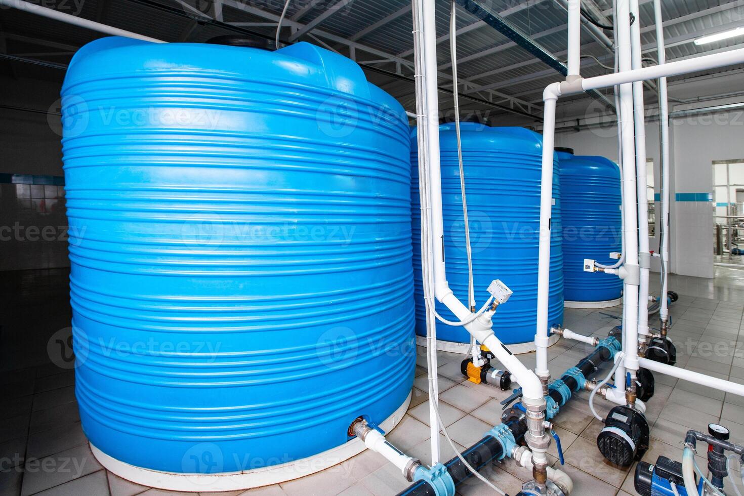 Large blue water storage tanks arranged systematically in a modern facility for liquid management and distribution photo