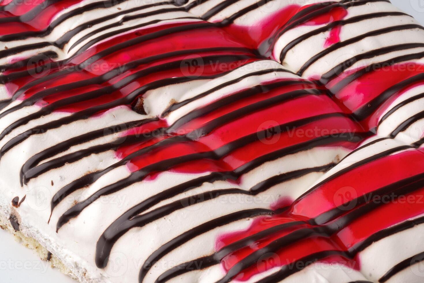 Delicious dessert featuring layers of cream, chocolate, and cherry sauce at a bakery photo