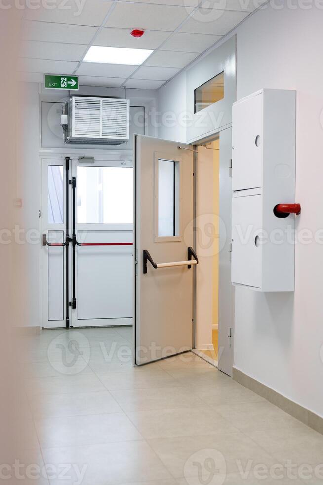 Interior hallway of a modern medical facility with a door leading to a treatment area in daylight photo