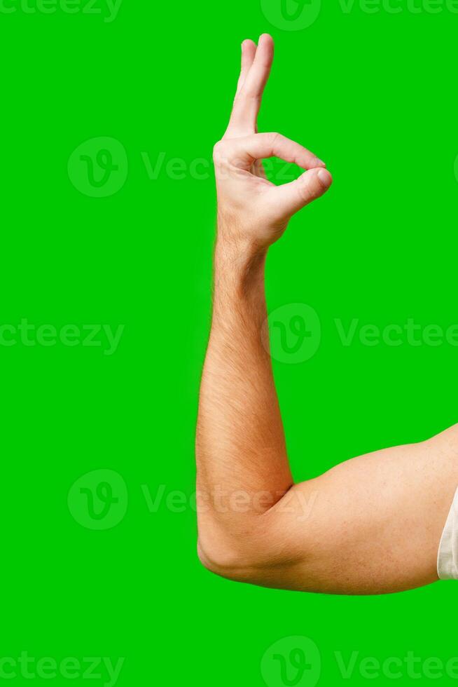 Hand Gesture Signifying Approval Against Bright Green Background photo