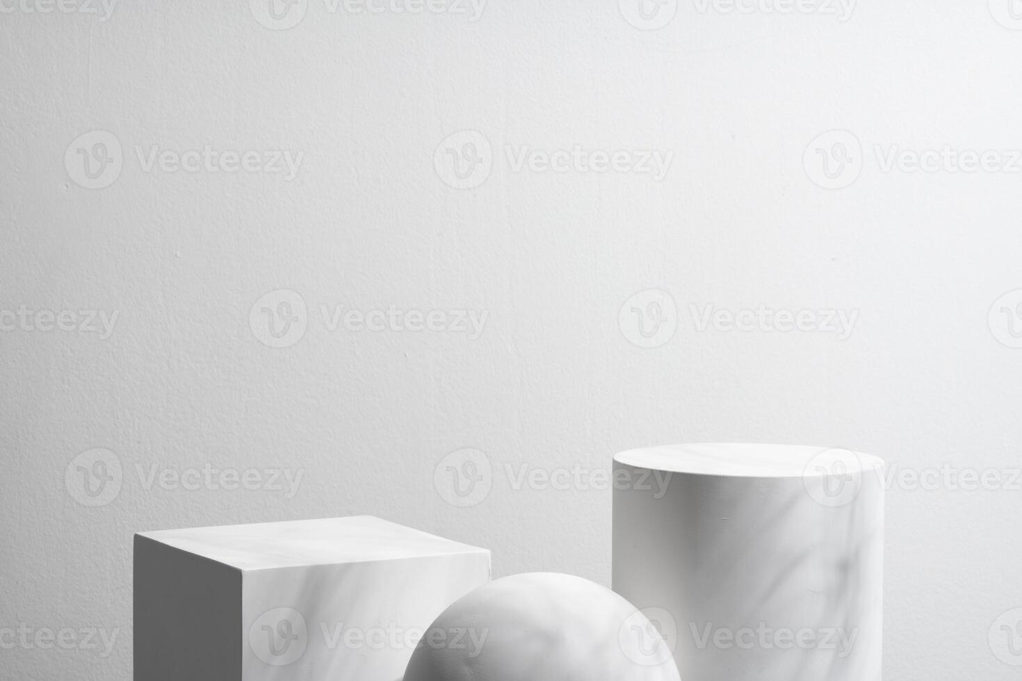 Abstract composition featuring three white geometric shapes in a minimalist interior setting photo