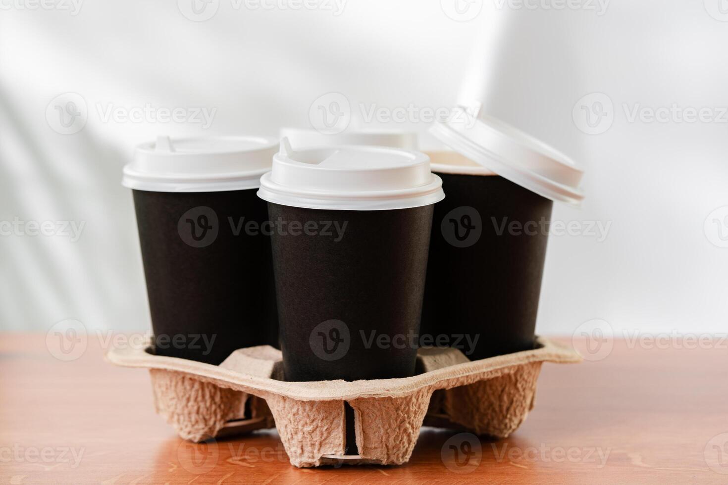 Stack of coffee cups in various colors with lids on a gray surface photo