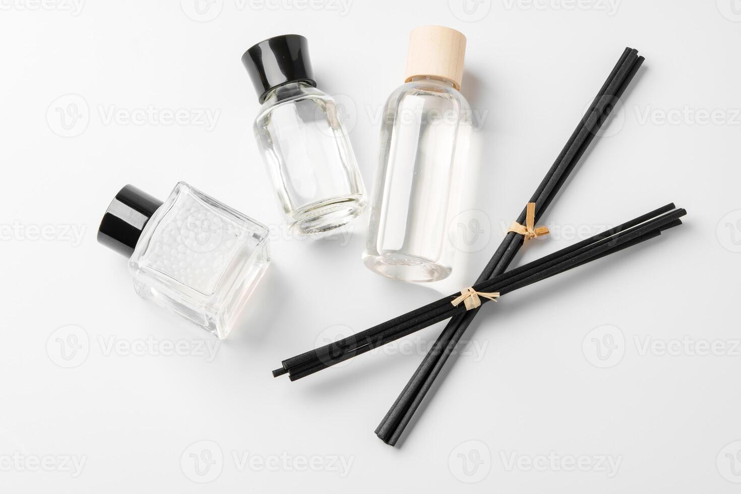 Elegant arrangement of essential oil diffusers with reeds and glass bottles on a minimalist surface photo