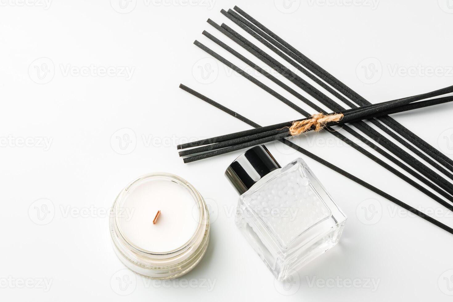 Aromatic essentials including scented candles, incense sticks, and diffusers arranged on a light background photo