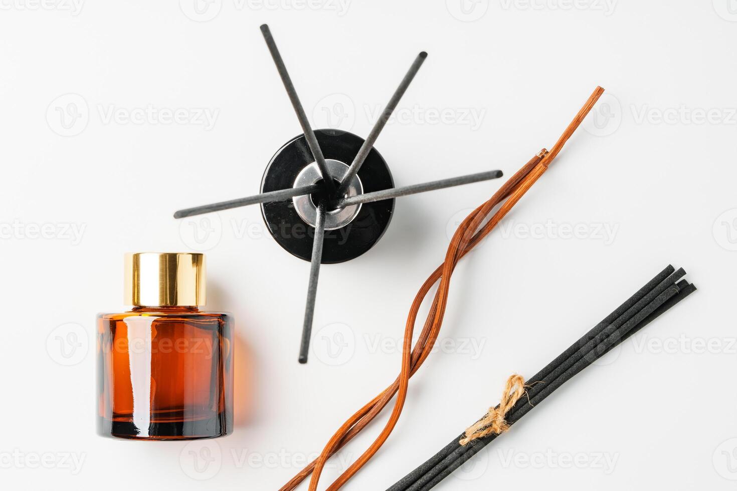 A minimalist display of essential oil and black diffuser sticks on a clean white background photo