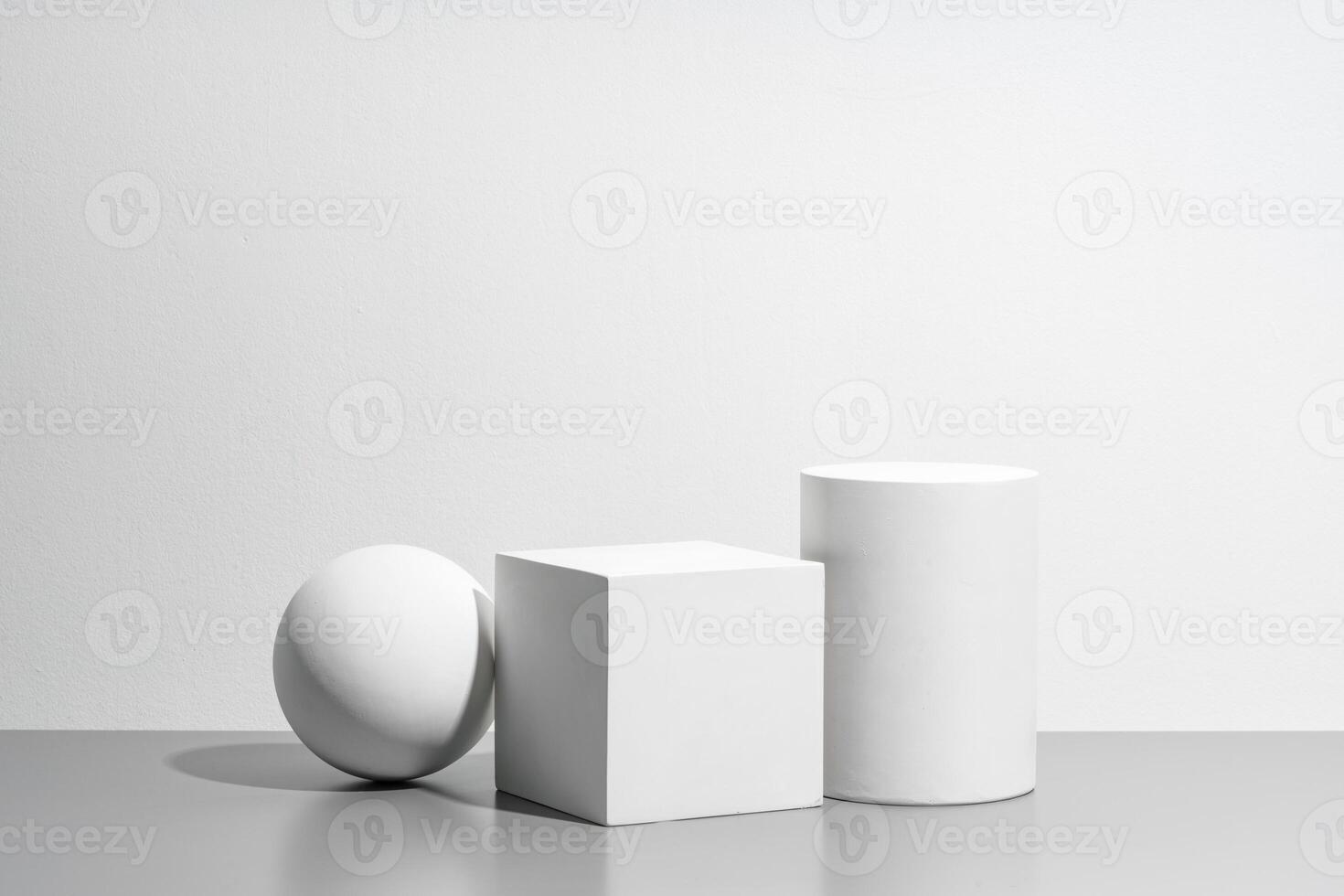 Abstract composition featuring three white geometric shapes in a minimalist interior setting photo