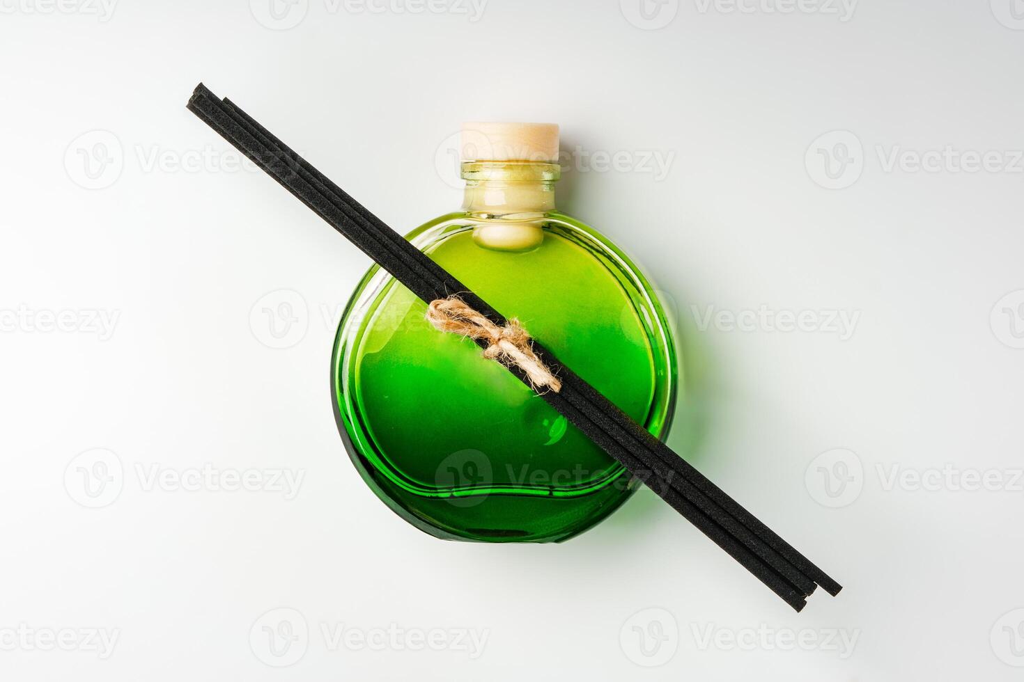 A minimalist display of essential oil and black diffuser sticks on a clean white background photo