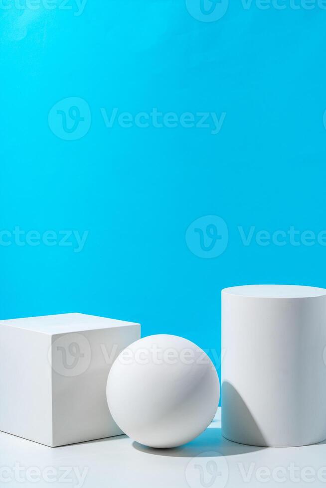 Three geometric shapes arranged on a table against a bright blue background during daytime lighting photo