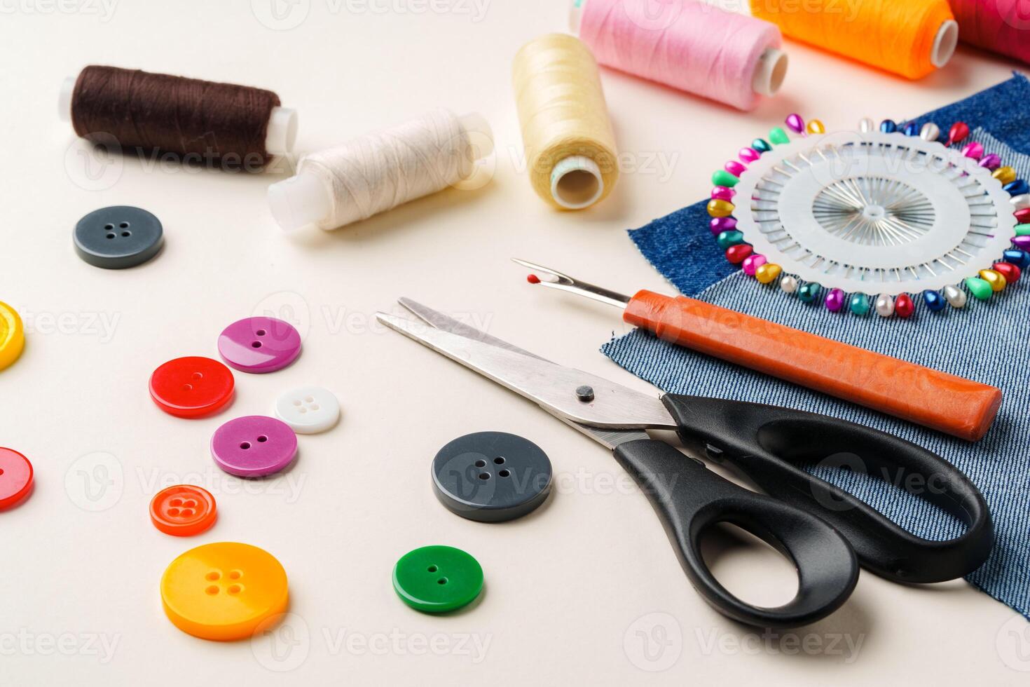 Sewing supplies and denim fabric arranged on a workspace for clothing alterations in a bright setting photo