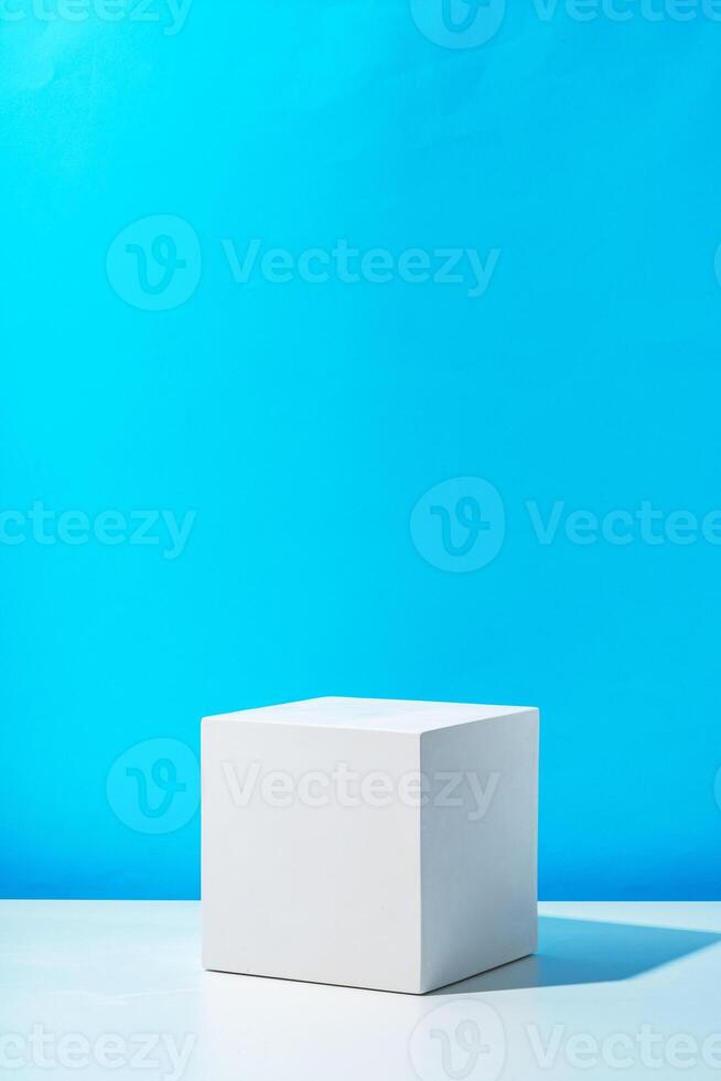 A clean white cube positioned on a minimalist surface against a vibrant blue backdrop photo