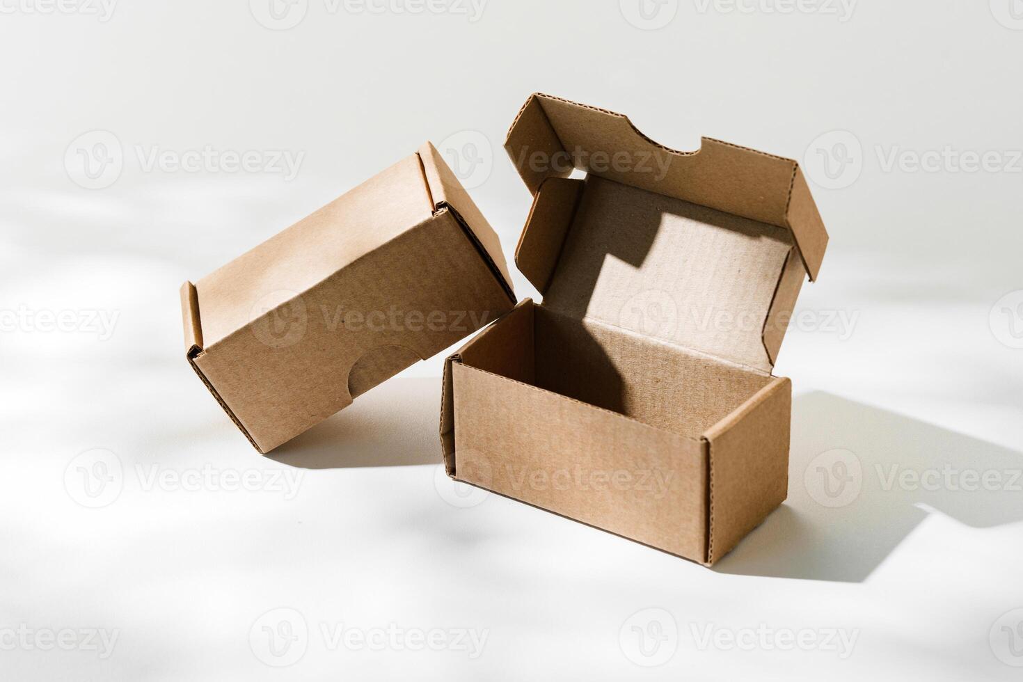 Open cardboard box on a reflective surface with soft shadows photo