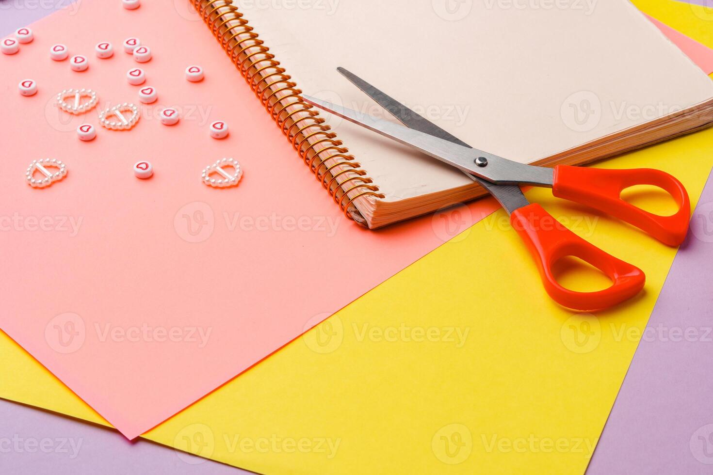 Scissors and decorative tape on colorful craft paper in a bright workspace photo