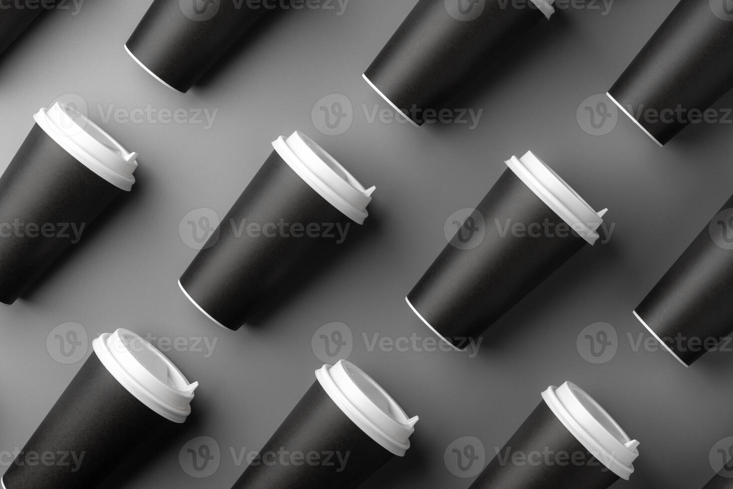Black disposable cups arranged on a gray surface with white lids, creating a look suitable for a coffee shop setting photo