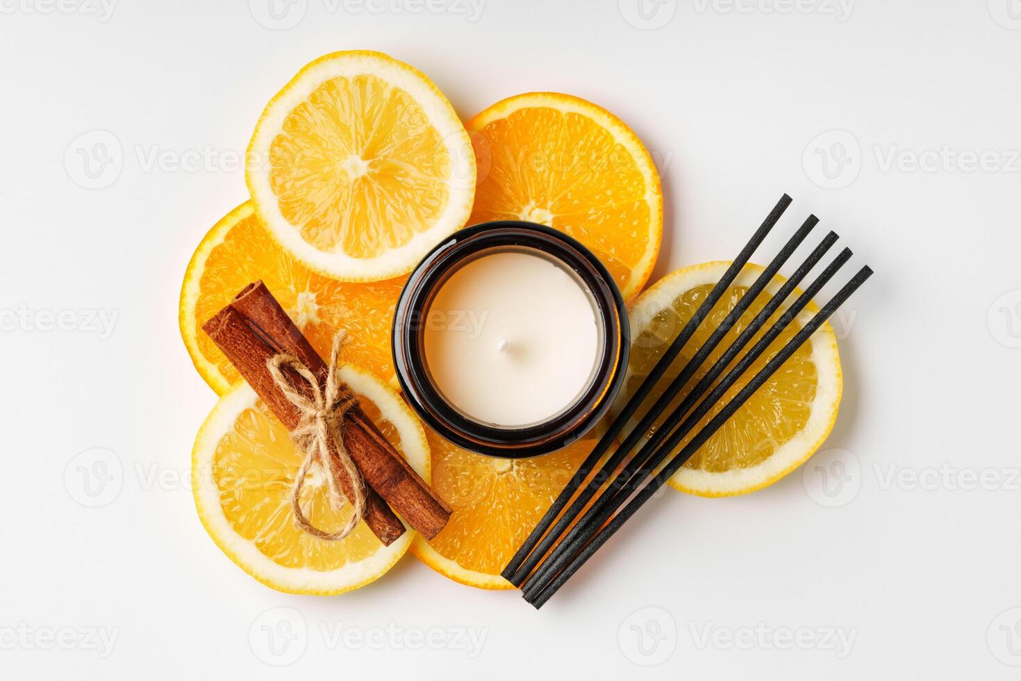 Aromatic arrangement featuring citrus slices and a scented candle on a white surface photo