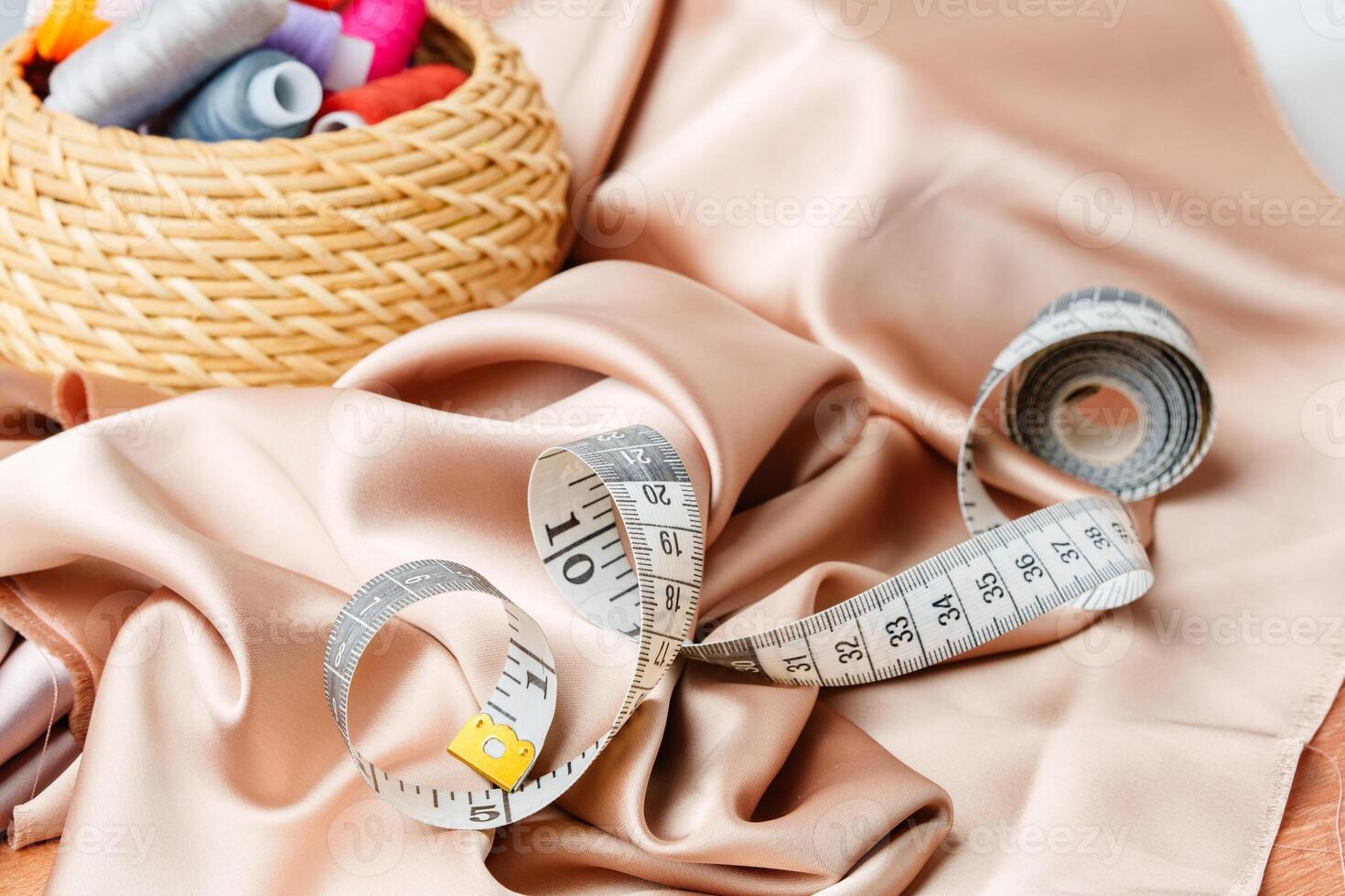 Colorful sewing supplies arranged neatly on a table surrounded by fabric photo