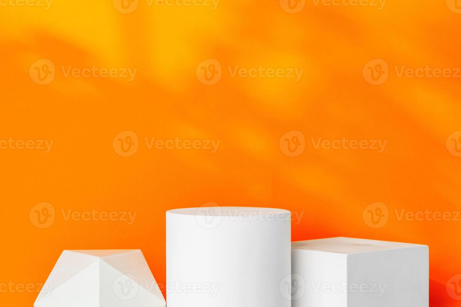 White geometric shapes on a vibrant orange background with soft shadows in a well-lit indoor setting photo