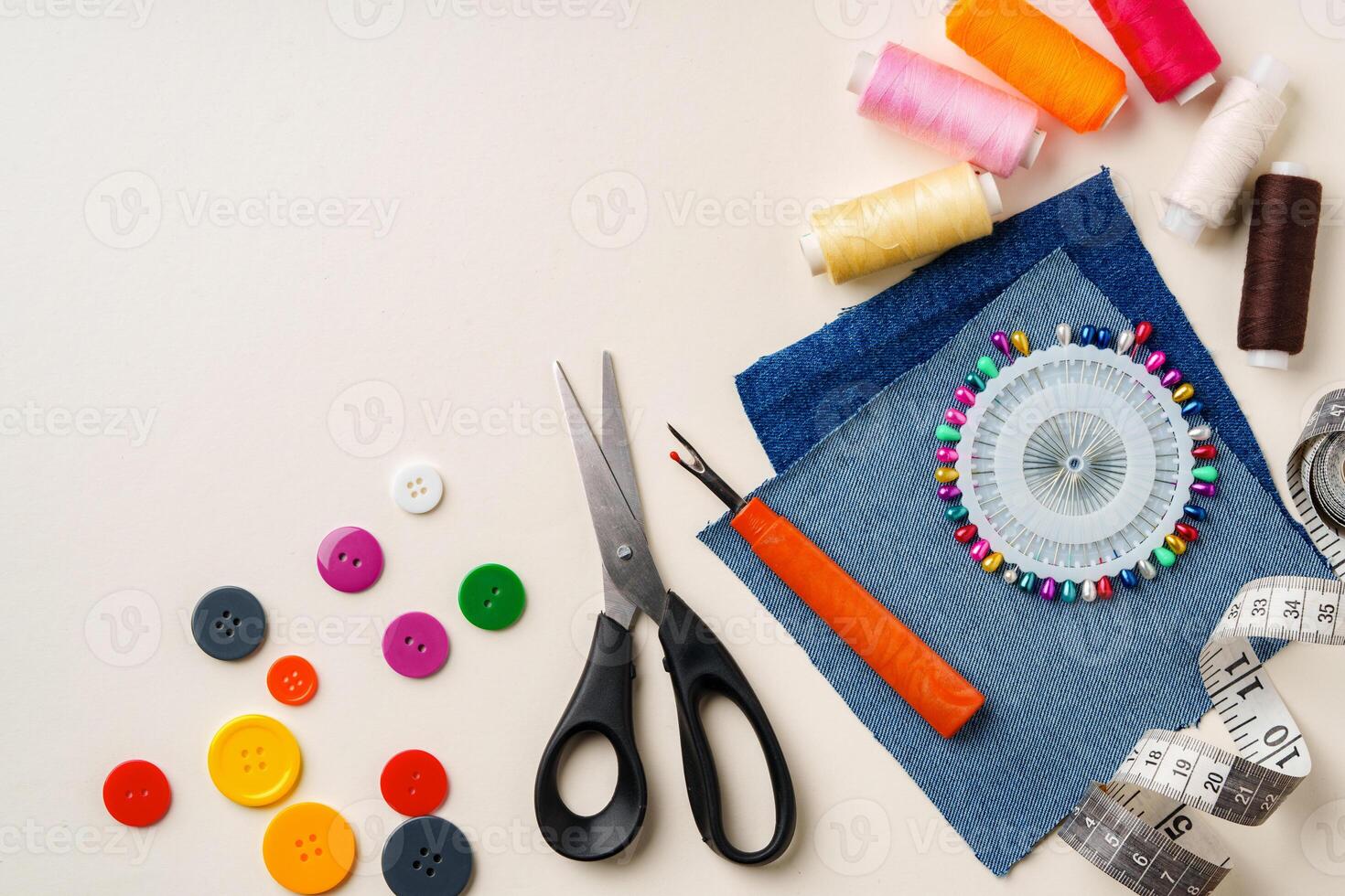 Sewing supplies and denim fabric arranged on a workspace for clothing alterations in a bright setting photo