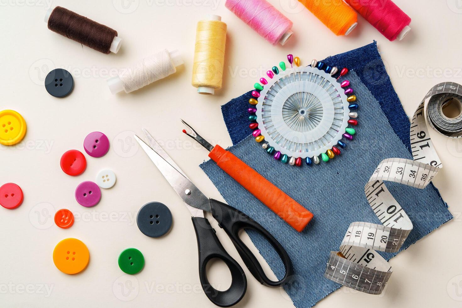 Sewing supplies and denim fabric arranged on a workspace for clothing alterations in a bright setting photo