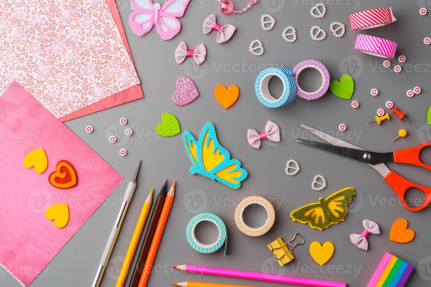 Crafting materials and tools arranged on a gray surface during a creative project photo