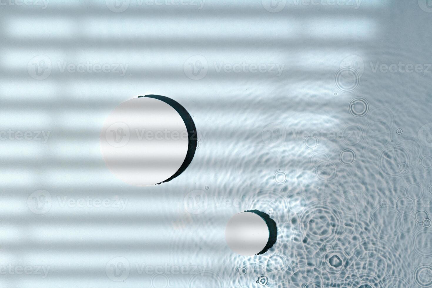 Raindrops create ripples on water surface with shadows from window blinds photo
