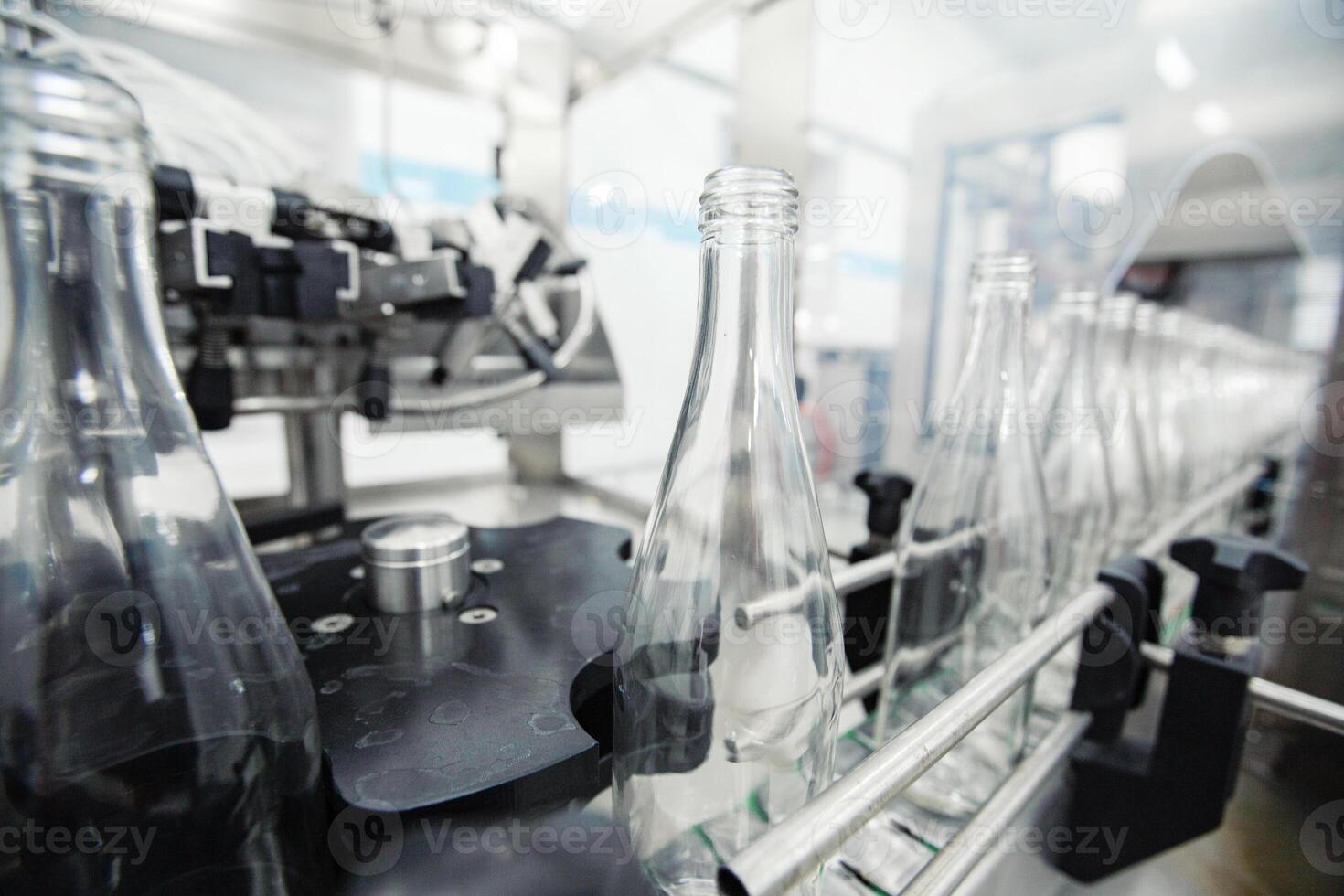 Bottling process in a modern beverage facility showcasing empty glass bottles on a conveyor belt photo