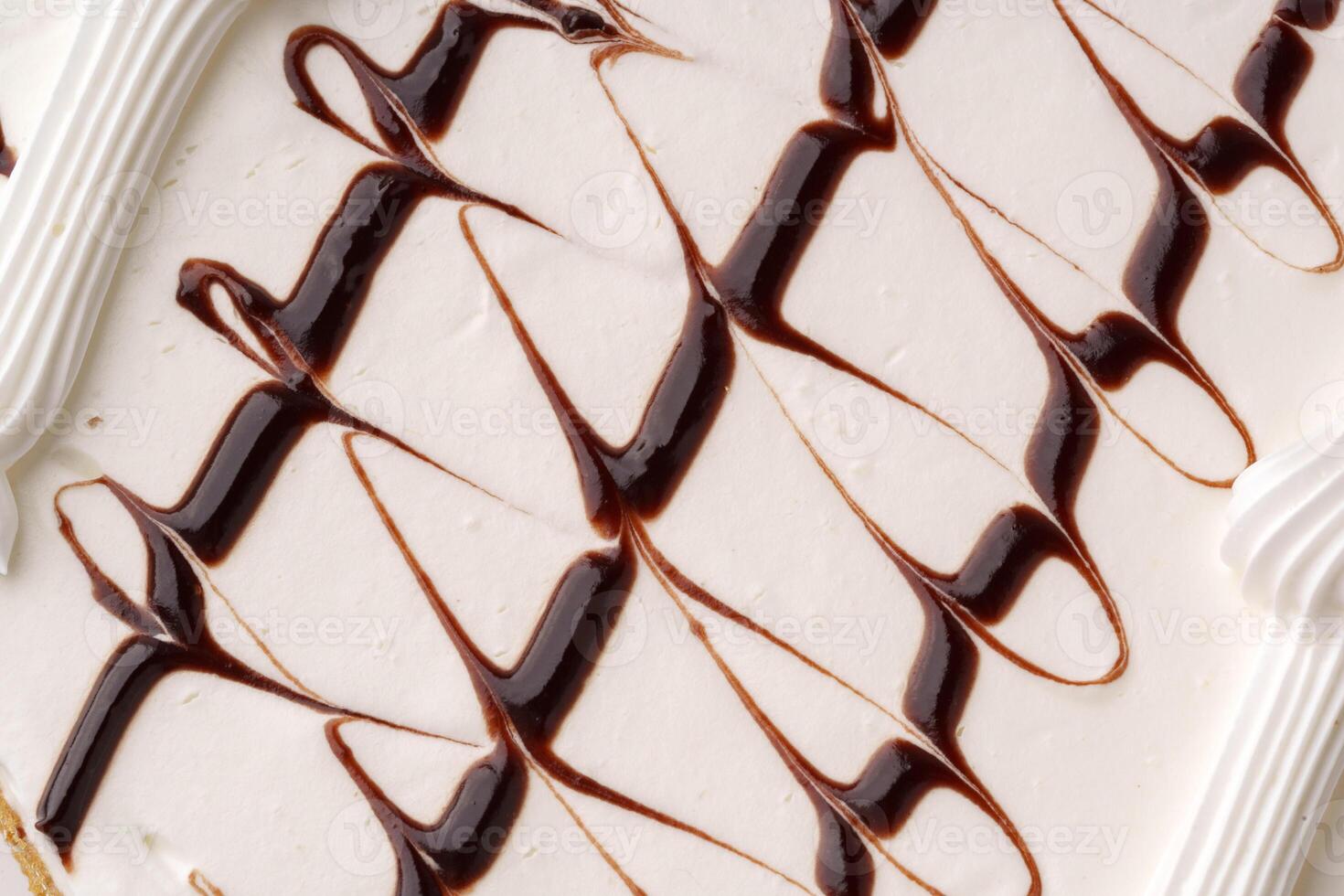 Delicious dessert featuring creamy vanilla ice cream swirled with chocolate sauce and topped with icing photo