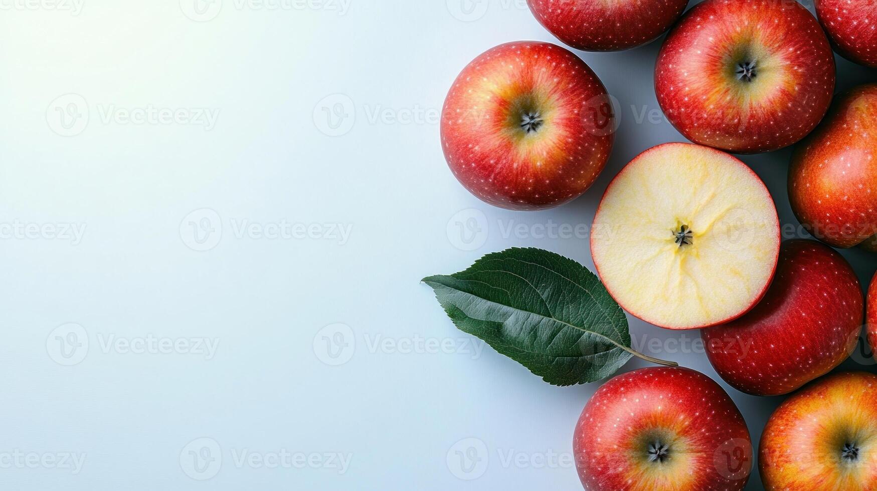 A cluster of vibrant red apples with one sliced open, showcasing its crisp interior photo