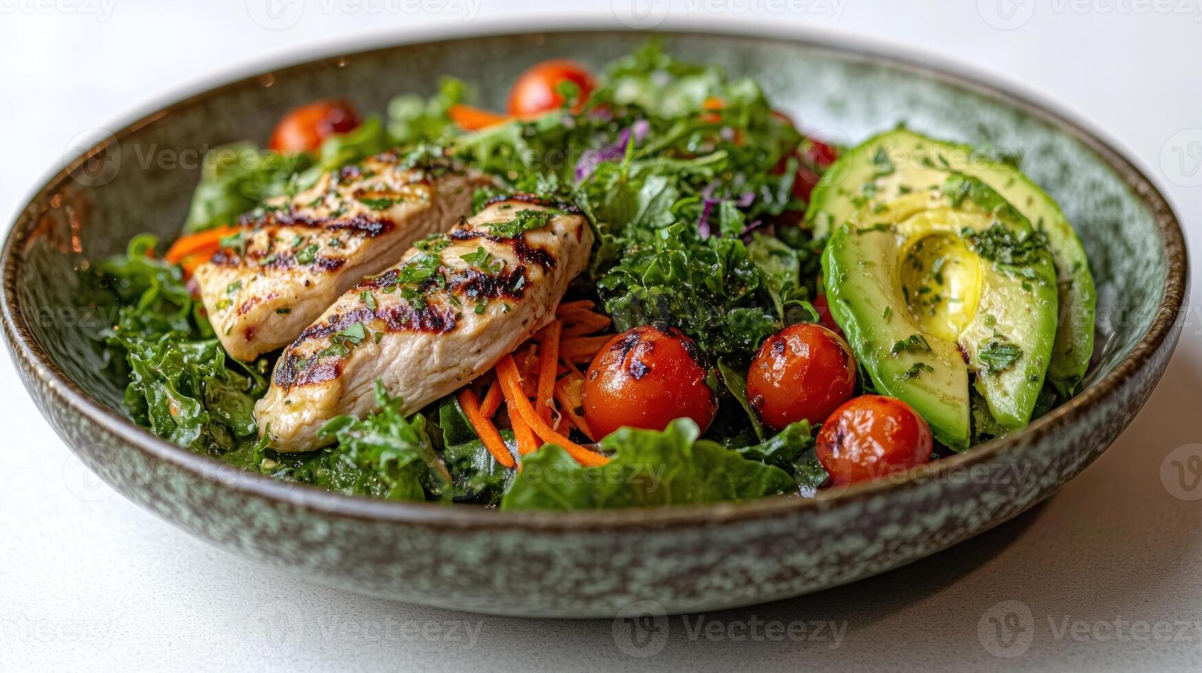 A colorful bowl brimming with grilled chicken, tomatoes, kale, and avocado photo