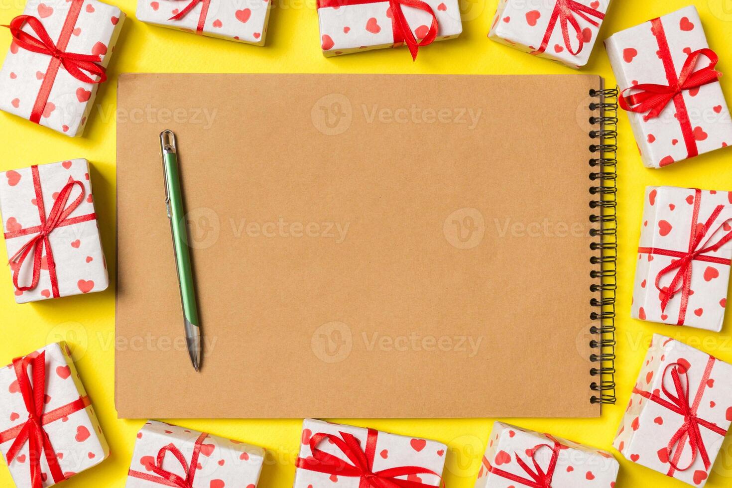 Top view of notebook surrounded with gift boxes colorful background. Valentine's Day concept photo