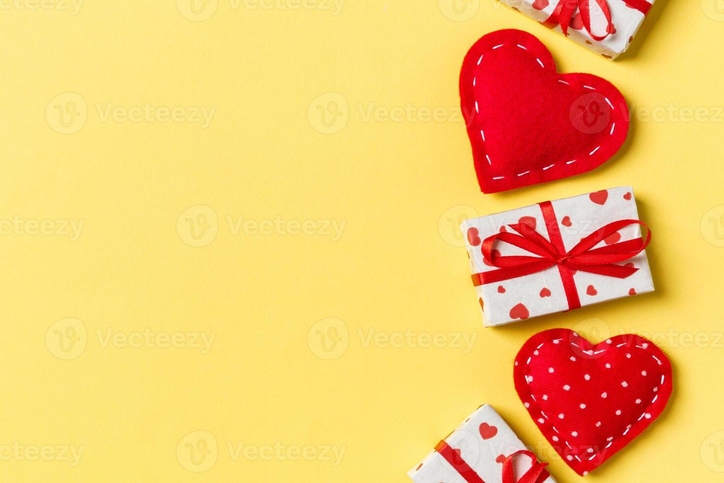 Holiday composition of gift boxes and red textile hearts background with empty space for your design. Top view of Valentine's Day concept photo