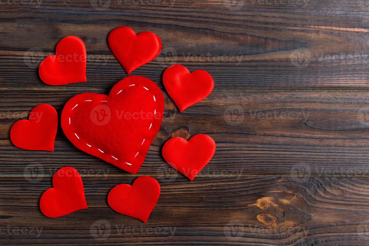 Top view composition of red hearts on wooden background. photo