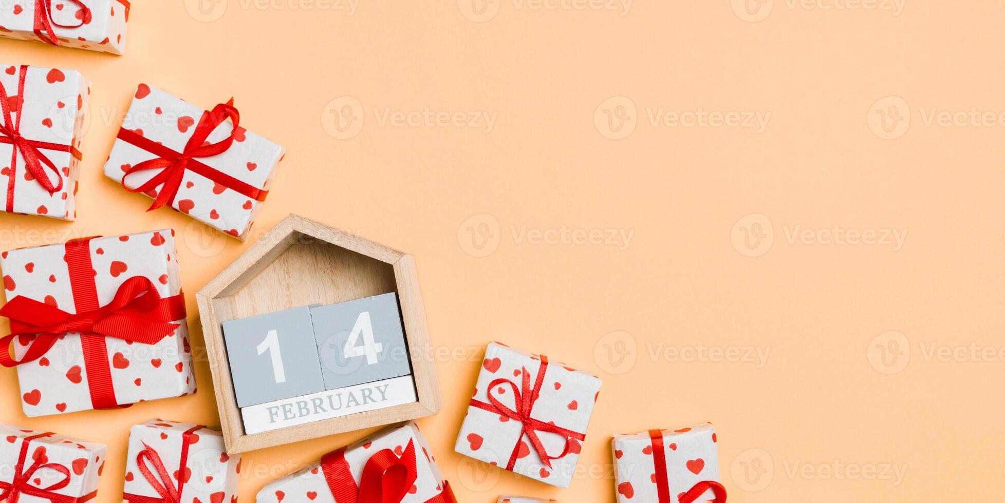 Top view of gift boxes with red hearts and wooden calendar photo