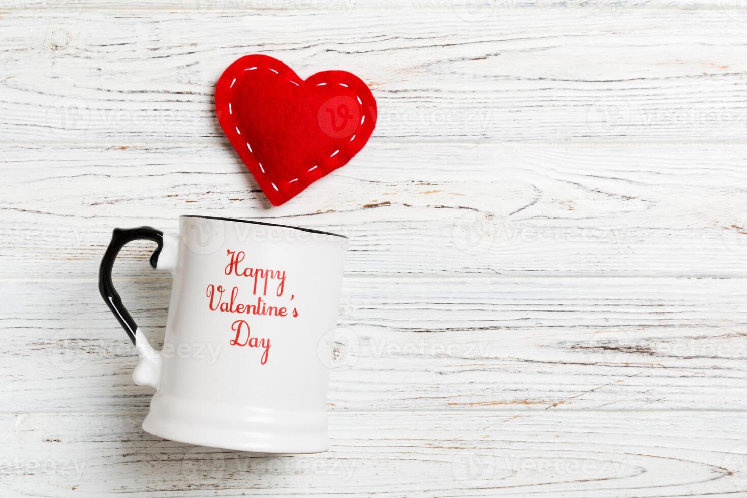 Top view of a cup and red hearts falling out from photo