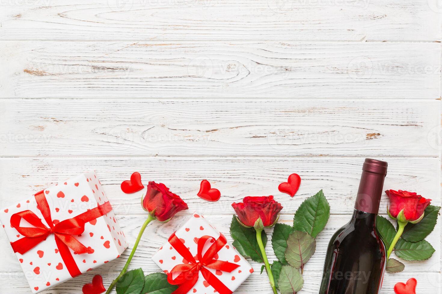 Valentine's day composition with red wine, and gift box on table. Top view, flat lay. Holiday concept photo