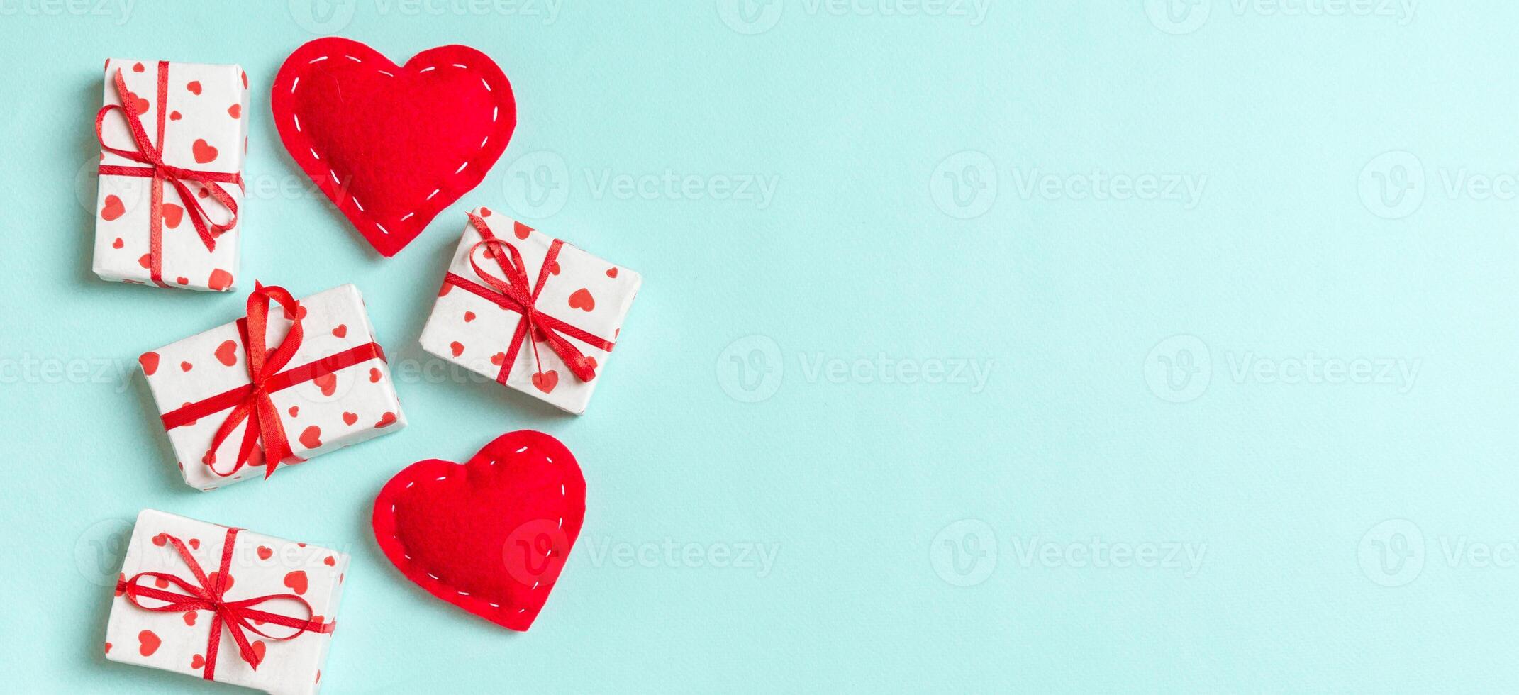 Holiday composition of gift boxes and red textile on colorful background with empty space for your design. Top view of Valentine's Day concept photo