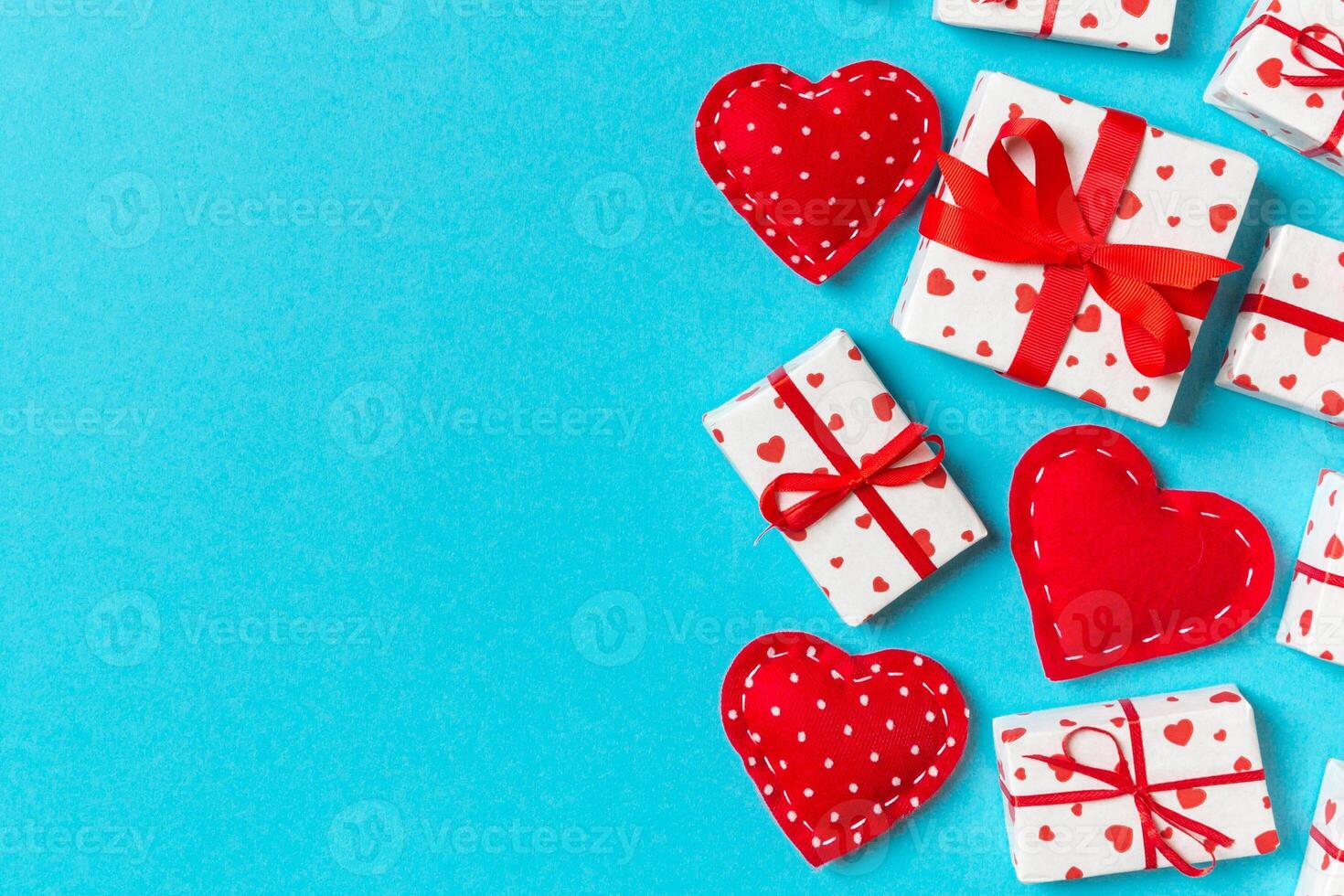 Top view colorful valentine made of gift boxes and red textile hearts. Valentine's Day concept with copy space photo