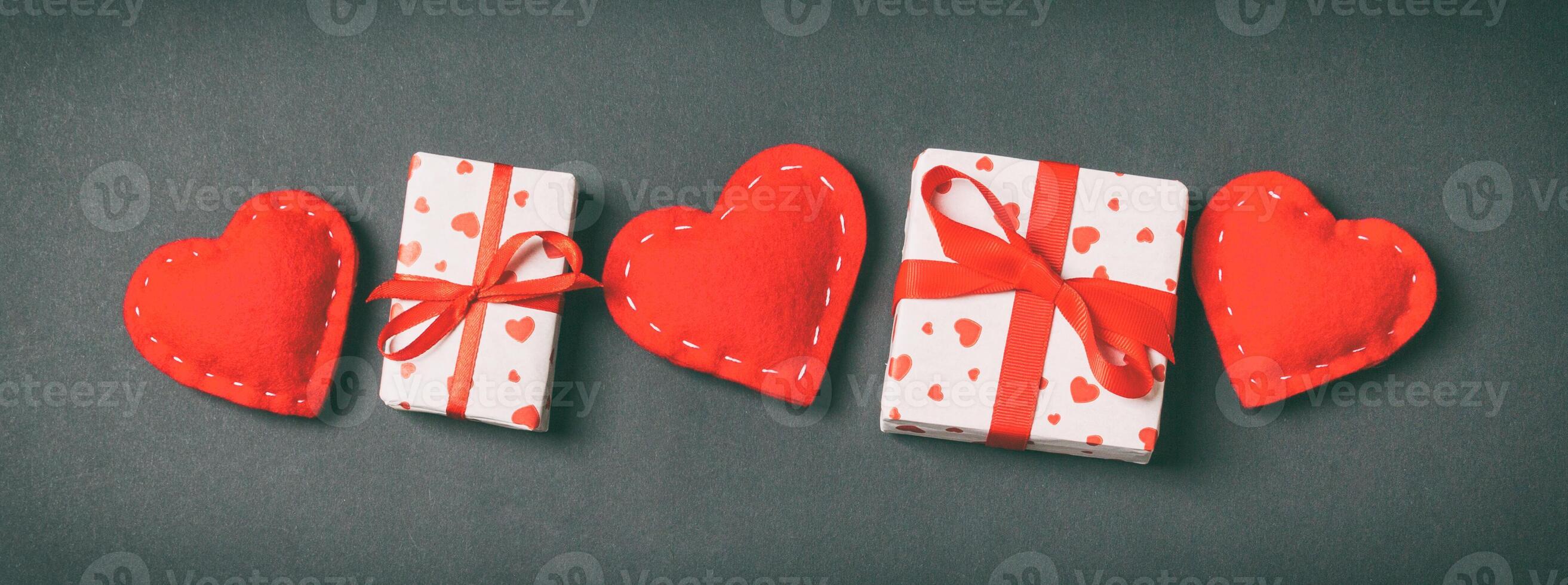 Holiday of gift boxes red textile hearts on colorful background with empty space for your design. Top view of Valentine's Day concept photo