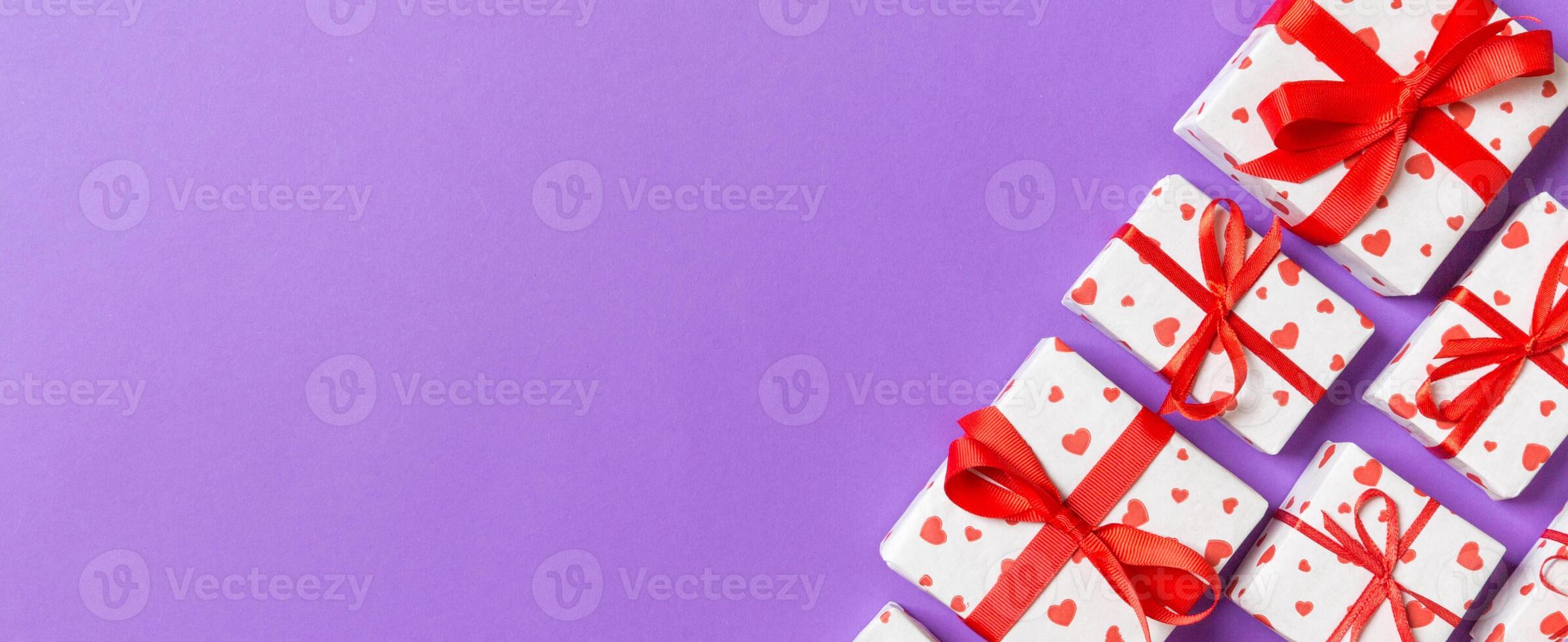 Holiday composition gift boxes with red hearts on colorful background with empty space for your design. Top view of Valentine's Day concept photo