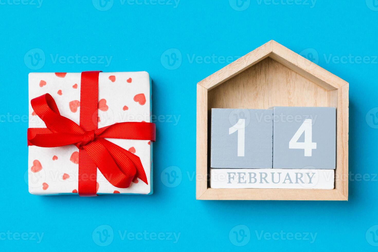 Top view white gift boxes with hearts and wooden calendar on colorful background. The fourteenth of February. Valentine's Day concept photo