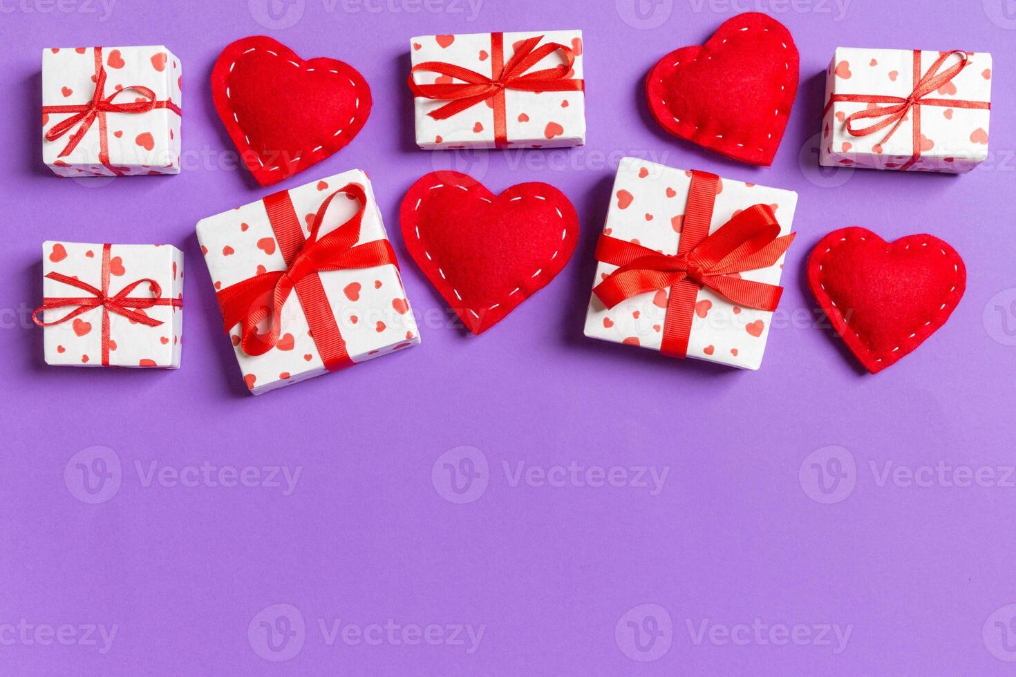 Top view colorful valentine made gift boxes and red textile hearts. Valentine's Day concept with copy space photo