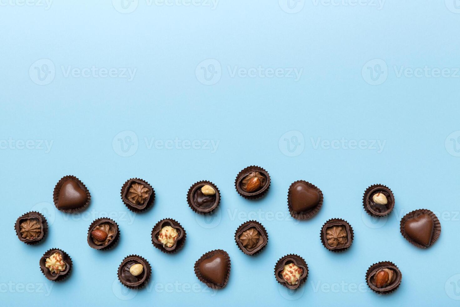 Different kinds of chocolates on colored table close. Top View and Flat Lay with copy space photo