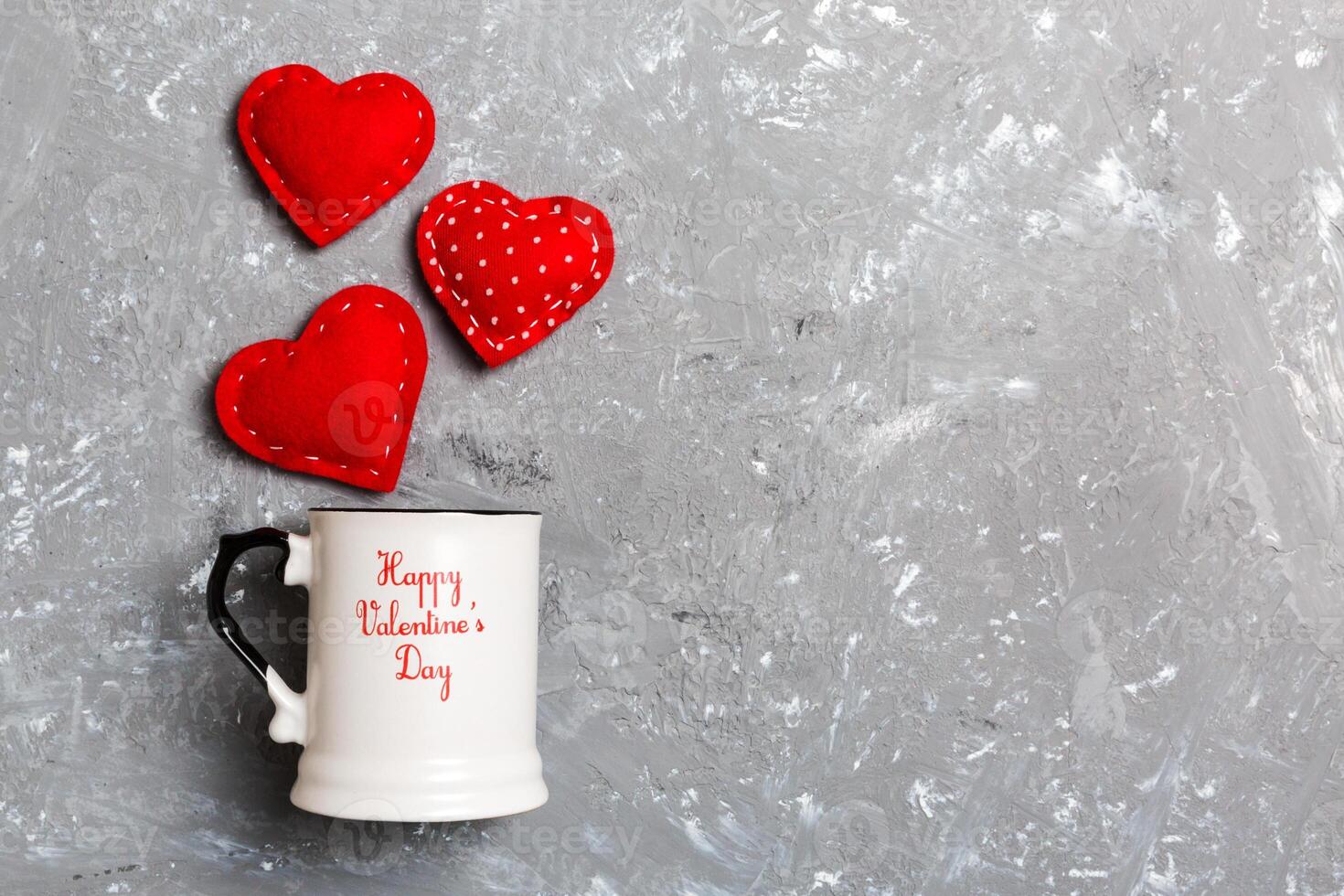 Top view composition hearts splashing out from a cup on cement background. Love and romance concept. Valentine's Day photo