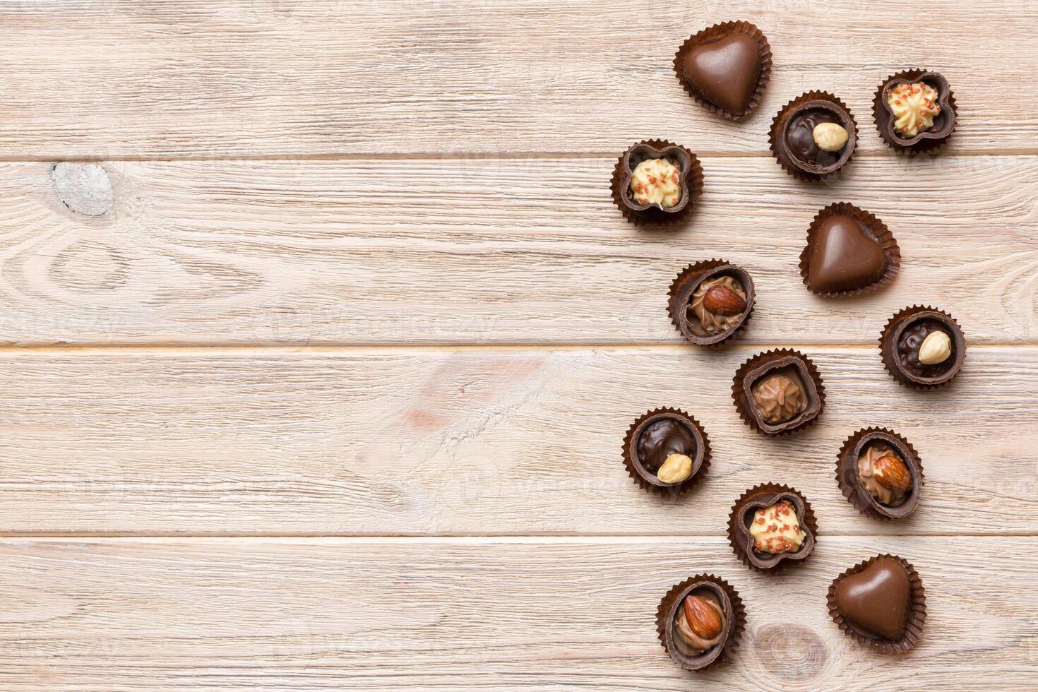 Different kinds of chocolates on colored table close up. Top View and Flat Lay with copy space photo