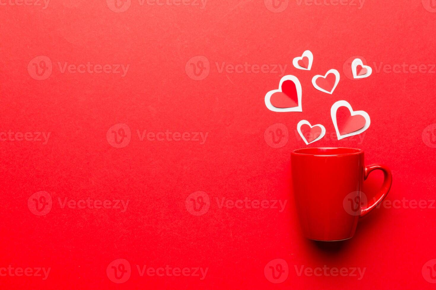 red cup on colored background, splashes red little hearts, top view with copy space photo
