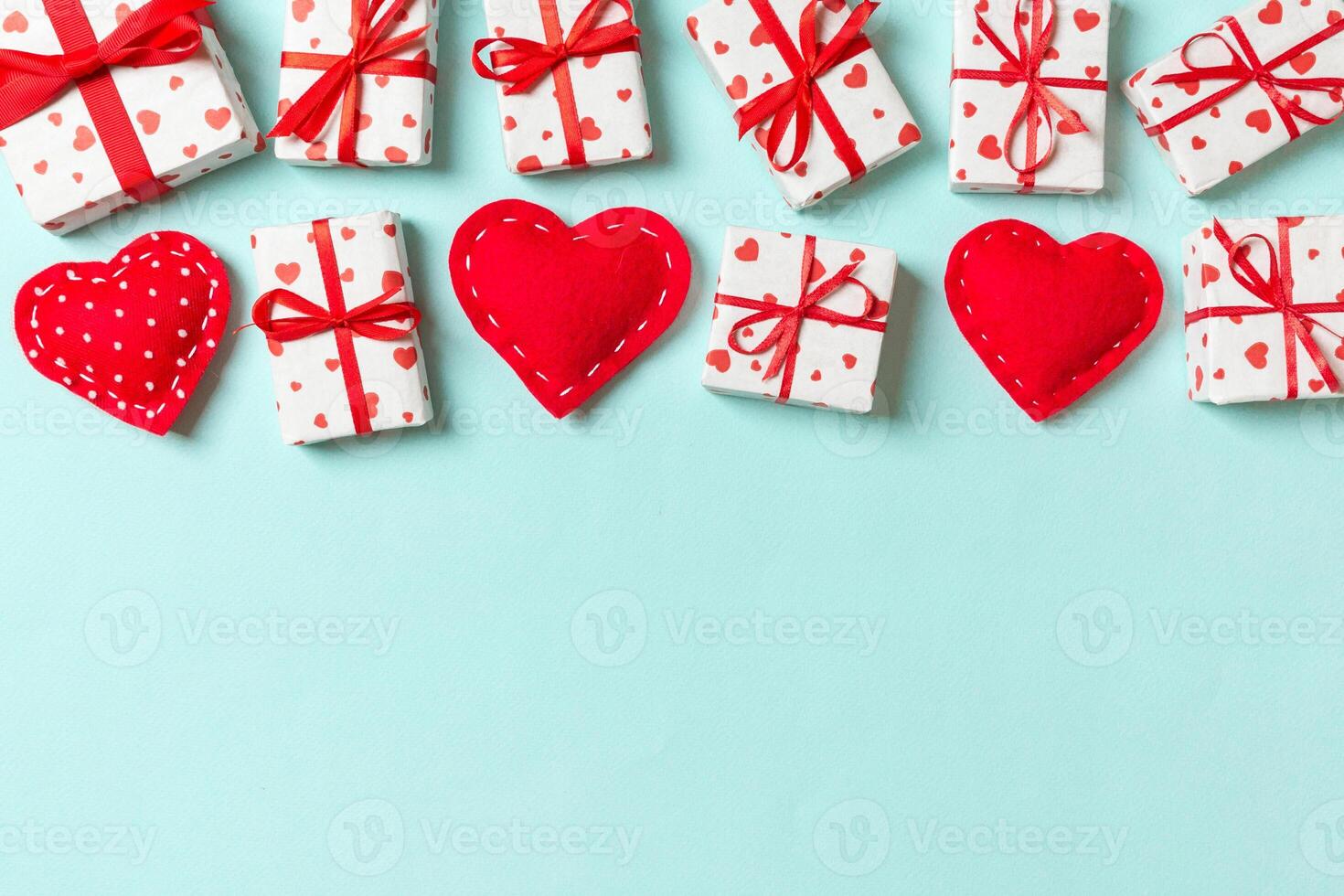 Top view of gift boxes and red textile hearts background. St Valentine's day concept with copy space photo