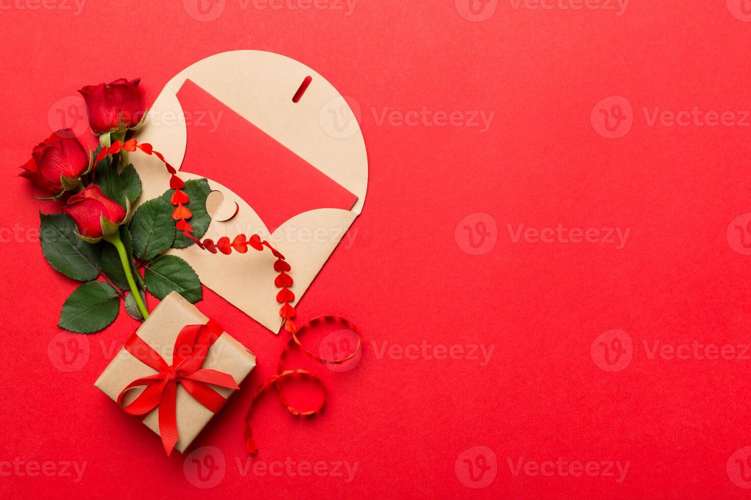 Valentine day composition envelope, rose flower and red heart on table. Top view, flat lay, copy space Holiday concept photo
