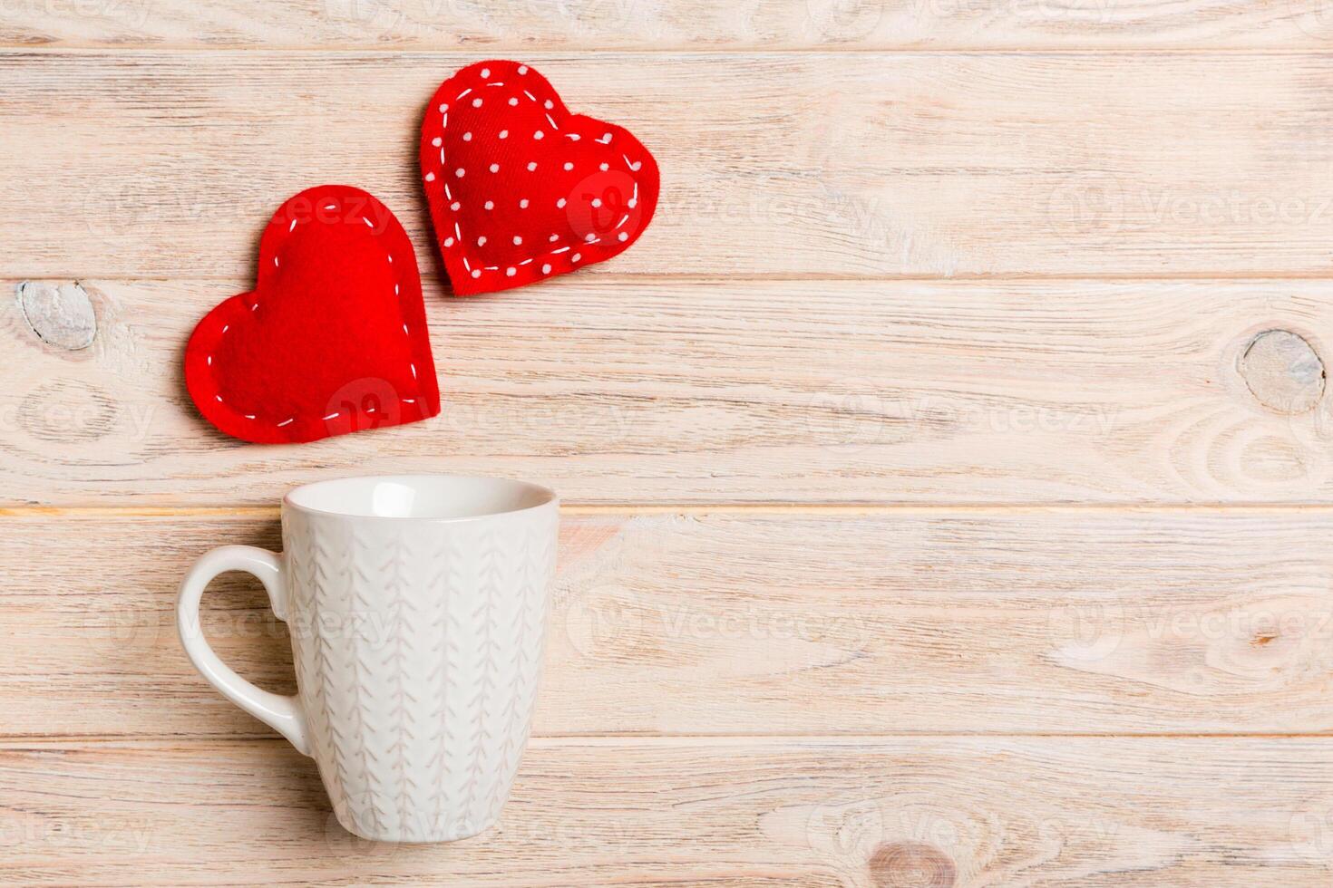 Top view of hearts splashing out from a cup on wooden background. Love and romance concept. Valentine's Day photo