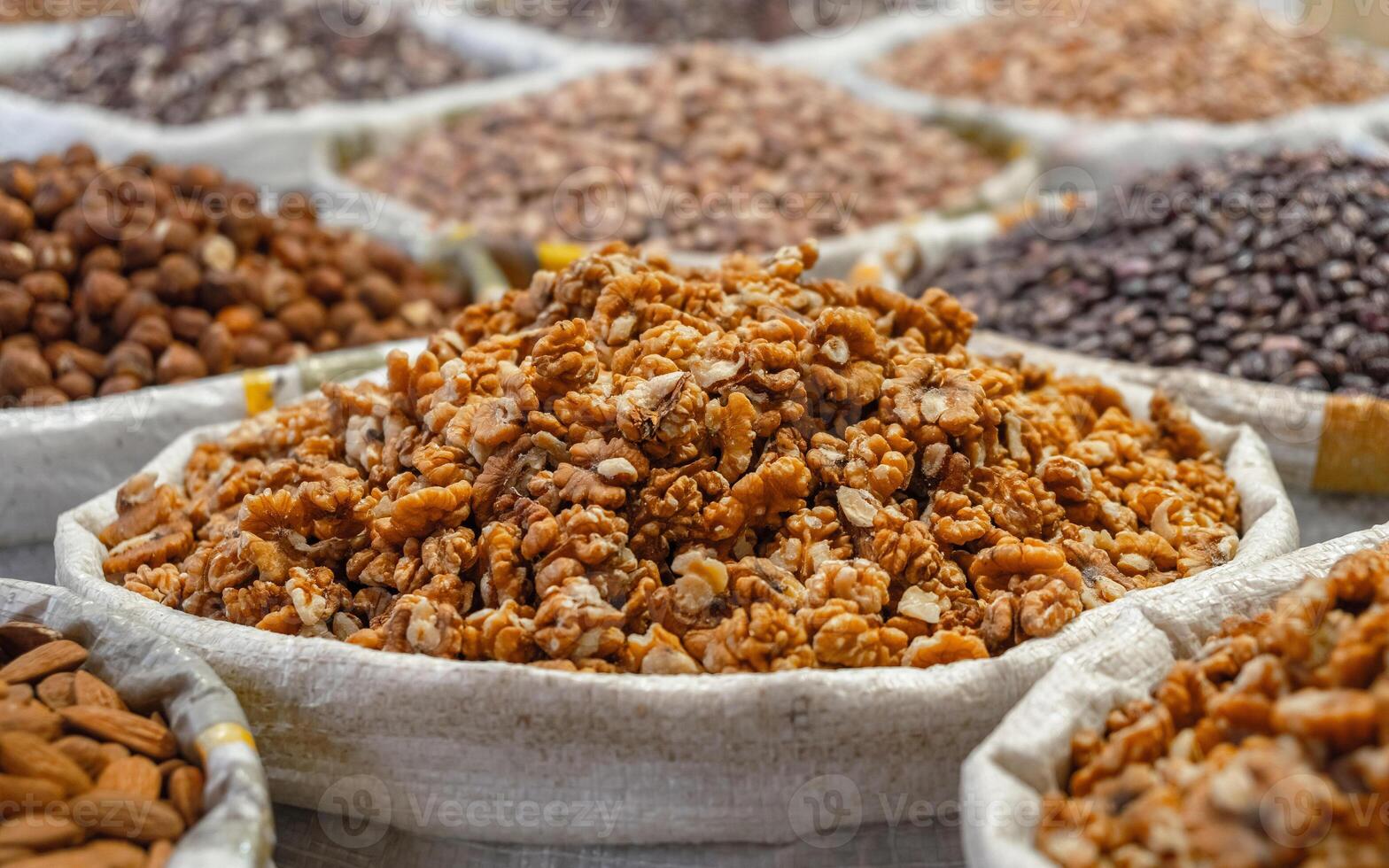 Close-up of walnuts in a bag on a market, with other nuts and seeds photo