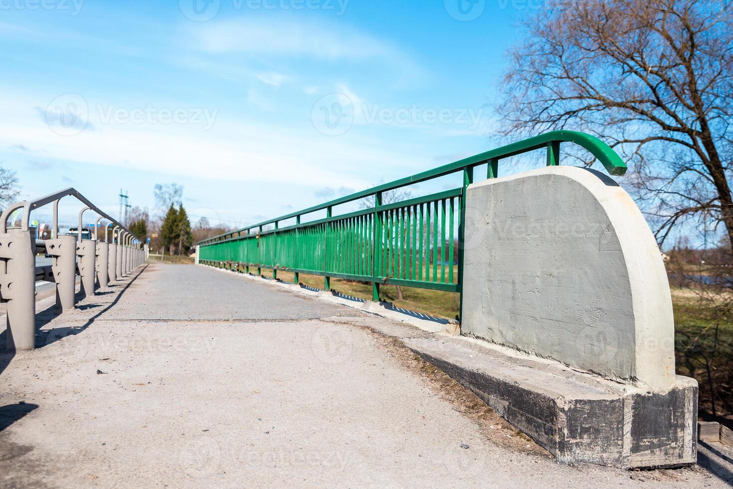 Pedestrian Bridge with Green Metal Railing and Concrete Base photo